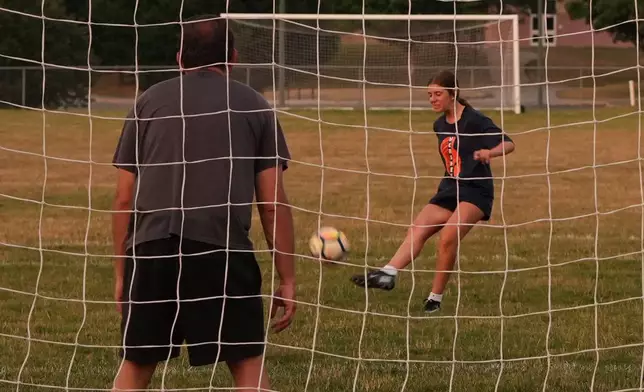 Cecelia Stefanelli, a rising freshman at Hershey High School, kicks a ball to score a goal against father, Justin Stefanelli, at a field where U.S. soccer national team star, Christian Pulisic, played when he was in school, in Hershey, Pa., on Tuesday, June 30, 2026. (AP Photo/Luis Andres Henao)