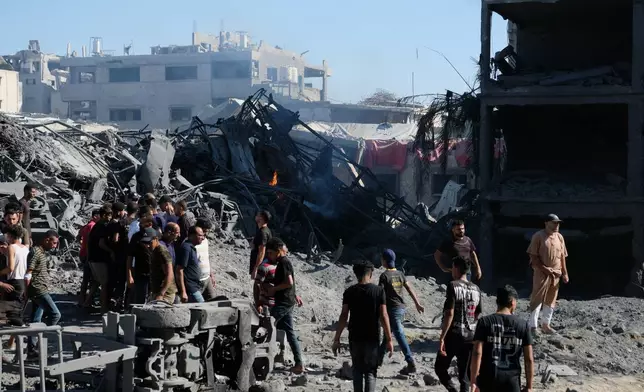 Palestinians gather around the site of an Israeli military drone strike on a blacksmith shop in Gaza City's Sabra neighborhood killing at least four Palestinians and wounded another, according to officials at Shifa hospital, where the casualties were taken on Sunday, July 12, 2026. (AP Photo/Jehad Alshrafi)