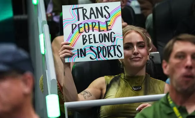 A person holds a "trans people belong in sports" sig during the first half of a WNBA basketball game between the Seattle Storm and the Indiana Fever, Tuesday, July 28, 2026, in Seattle. (AP Photo/Lindsey Wasson)