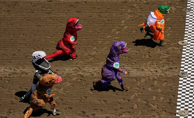 Participants in the preliminary heats approach the finish line during the T-Rex World Championship Races at Emerald Downs, Sunday, July 12, 2026, in Auburn, Wash. (AP Photo/Lindsey Wasson)