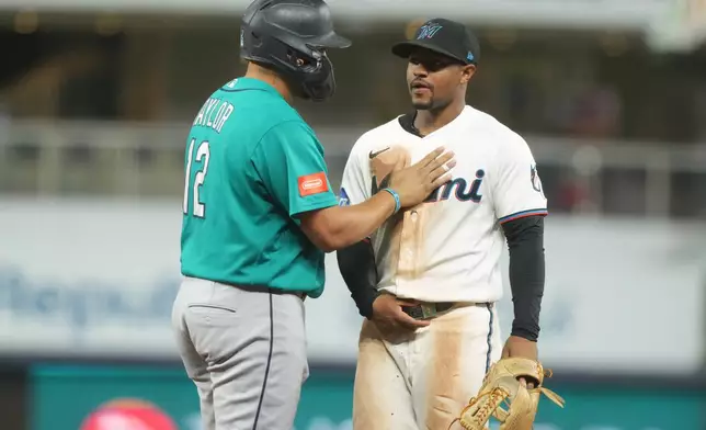Seattle Mariners' Josh Naylor (12) and Miami Marlins second baseman Xavier Edwards exchange words during the eighth inning of a baseball game Tuesday, July 7, 2026, in Miami. (AP Photo/Marta Lavandier)