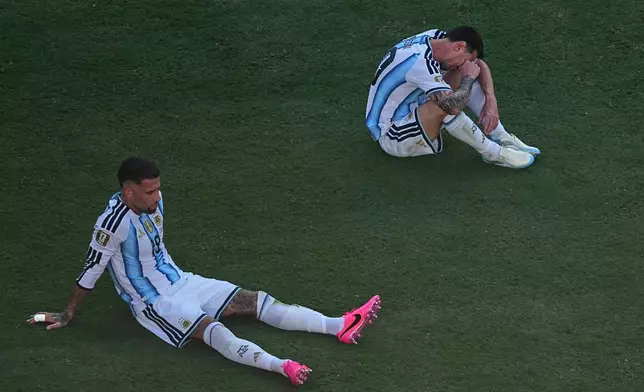 Argentina's Nicolas Otamendi (19) and Lionel Messi (10) sit dejected after during the World Cup final soccer match between Spain and Argentina in East Rutherford, N.J., near New York, Sunday, July 19, 2026. (AP Photo/Matt Rourke)
