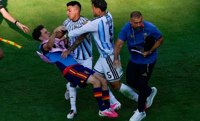 Spain's Gavi, left, falls as he scuffles with Argentina's Leandro Paredes (5) and Thiago Almada during the World Cup final soccer match between Spain and Argentina in East Rutherford, N.J., near New York, Sunday, July 19, 2026. (AP Photo/Yuki Iwamura)