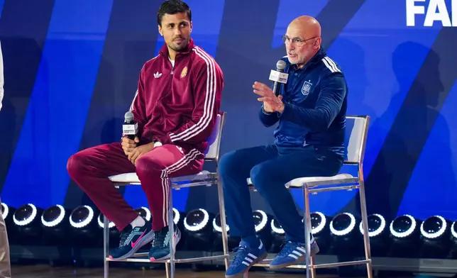 Spain's Rodri listens as head coach Luis de la Fuente speaks during a news conference ahead of the World Cup final soccer match between Spain and Argentina in New York, Friday, July 17, 2026. (AP Photo/Stephanie Scarbrough)