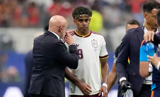 Spain head coach Luis de la Fuente speaks to Spain's Lamine Yamal during the World Cup semifinal soccer match between France and Spain in Arlington, Texas, near Dallas, Tuesday, July 14, 2026. (AP Photo/Ashley Landis)
