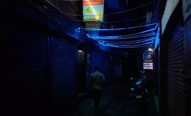 A man walks down an alley in a bustling neighborhood of Kathmandu, Nepal, Thursday, May 21, 2026. (AP Photo/Bram Janssen)