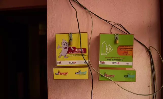 An empty condom dispenser hangs outside an office in Kathmandu, Nepal, Tuesday, May 12, 2026. (AP Photo/Bram Janssen)