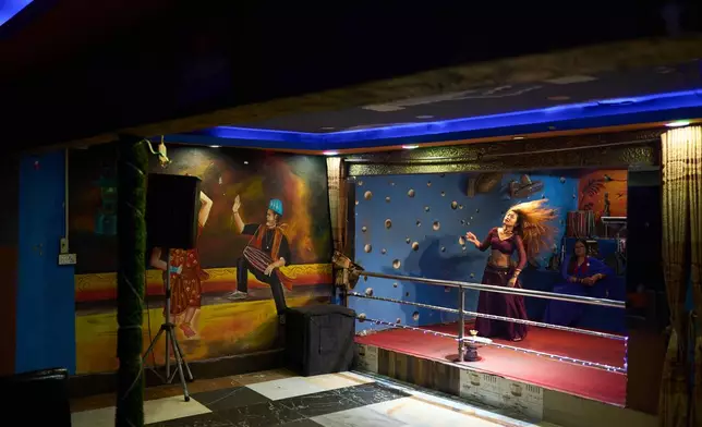 A dancer performs in a club in Hetauda, Nepal, Saturday, May 16, 2026. (AP Photo/Bram Janssen)