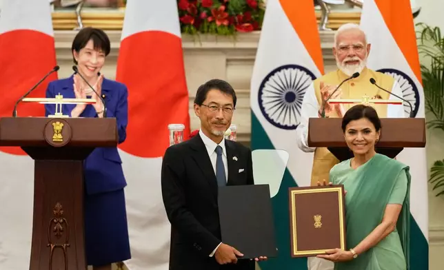 Japan's Prime Minister Sanae Takaichi, left, and India's Prime Minister Narendra Modi, right, applaud as Japan's ambassador to India Ono Keiichi, center left, and India's ambassador to Japan Nagma Mohamed Mallick hold copies of a signed bilateral agreement after their delegation level meeting in New Delhi, India, Thursday, July 2, 2026. (AP Photo/Manish Swarup)
