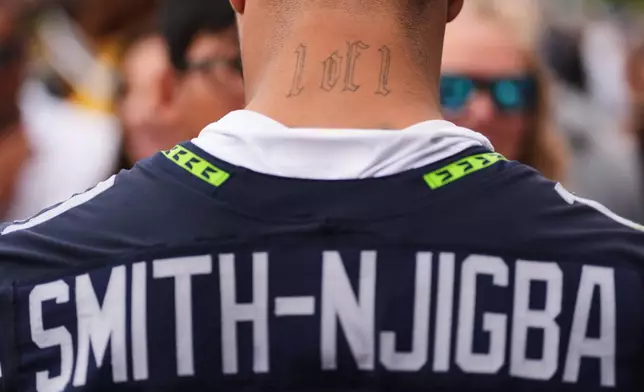 Seattle Seahawks wide receiver Jaxon Smith-Njigba signs autographs during the NFL football team's training camp, Sunday, July 26, 2026, in Renton, Wash. (AP Photo/Lindsey Wasson)