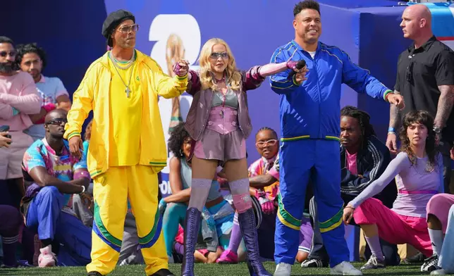 Ronaldinho, left, and Ronaldo stand with Madonna as she performs during the halftime show in the World Cup final soccer match between Spain and Argentina in East Rutherford, N.J., near New York, Sunday, July 19, 2026. (AP Photo/Julio Cortez)
