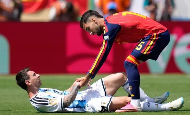 Spain's Alex Baena helps Argentina's Lionel Messi get back on his feet after a foul during the World Cup final soccer match between Spain and Argentina in East Rutherford, N.J., near New York, Sunday, July 19, 2026. (AP Photo/Ashley Landis)
