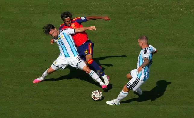 Argentina's Nicolas Tagliafico (3) and Spain's Lamine Yamal battle for control as Argentina's Alexis Mac Allister, right, defends during the World Cup final soccer match between Spain and Argentina in East Rutherford, N.J., near New York, Sunday, July 19, 2026. (AP Photo/Yuki Iwamura)
