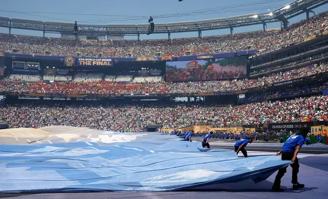 Staff uncover the ground before the start of the World Cup championship final soccer match between Spain and Argentina in East Rutherford, N.J., Sunday, July 19, 2026. (AP Photo/Jacquelyn Martin)