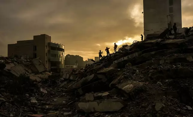 FILE - Men searching for survivors stand atop a mountain of rubble three days after twin earthquakes struck, in La Guaira, Venezuela, June 27, 2026. (AP Photo/Matias Delacroix, File)
