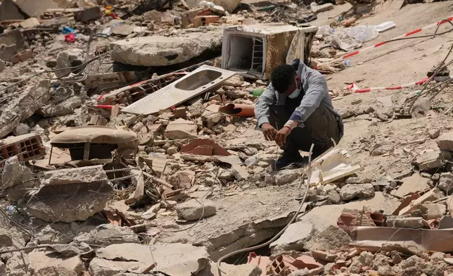 FILE - A man sits amid earthquake rubble in La Guaira, Venezuela, June 29, 2026. (AP Photo/Matias Delacroix, File)