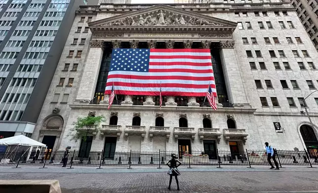 FILE - People pass the New York Stock Exchange on May 28, 2024, in New York. (AP Photo/Peter Morgan, File)
