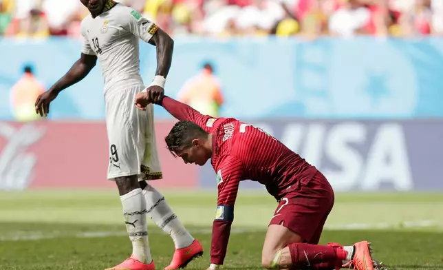 FILE - Ghana's Jonathan Mensah helps Portugal's Cristiano Ronaldo get up after he missed a chance to score during the group G World Cup soccer match in Brasilia, Brazil, June 26, 2014. (AP Photo/Marcio Jose Sanchez, File)