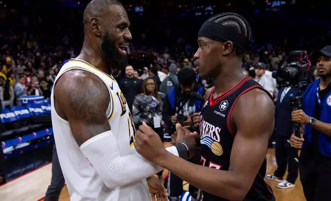 FILE - Los Angeles Lakers' LeBron James, left, talks with Philadelphia 76ers' VJ Edgecombe, right, following an NBA basketball game, Dec. 7, 2025, in Philadelphia. (AP Photo/Chris Szagola, File)