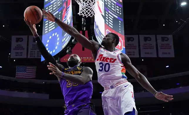 FILE - Los Angeles Lakers' LeBron James, left, goes up for a shot past Philadelphia 76ers' Adem Bona during the second half of an NBA basketball game, Jan. 28, 2025, in Philadelphia. (AP Photo/Matt Slocum, File)