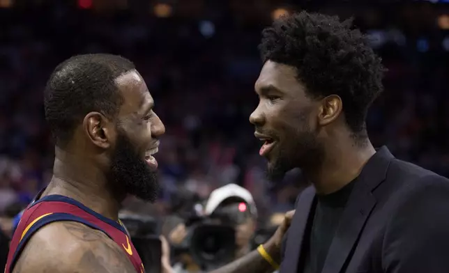 FILE - Cleveland Cavaliers' LeBron James, left, talks with Philadelphia 76ers' Joel Embiid, right, of Cameroon, after the second half of an NBA basketball game, April 6, 2018, in Philadelphia. (AP Photo/Chris Szagola, File)