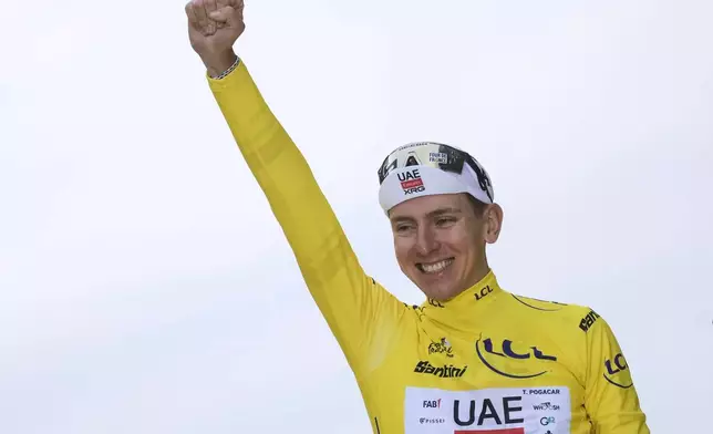 FILE - Tour de France winner Tadej Pogacar of Slovenia celebrates on the podium after the twenty-first stage of the Tour de France cycling race over 132.3 kilometers (82.1 miles) with start in Mantes-la-Ville and finish on the Champs-Elysees in Paris, France, on July 27, 2025. (AP Photo/Thibault Camus, File)