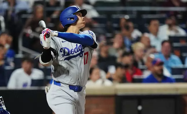 Los Angeles Dodgers' Shohei Ohtani follows through on a sacrifice fly ball to drive in a run during the seventh inning of a baseball game against the New York Mets Friday, July 24, 2026, in New York. (AP Photo/Frank Franklin II)