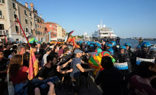 Police officers confront demonstrators gathered to protest against U.S. Ambassador Tilman Fertitta's superyacht 'Boardwall' presence in Venice, Friday, July 17, 2026. (AP Photo/Luca Bruno)