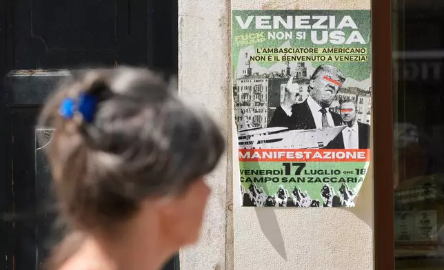 A poster of the protest against U.S. Ambassador Tilman Fertitta's superyacht 'Boardwall' presence, hangs on a wall in Venice, Friday, July 17, 2026. (AP Photo/Luca Bruno)