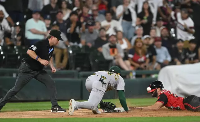 Chicago White Sox's Tristan Peters, right, slides safely into third base for an RBI triple while the Athletics third baseman Joshua Kuroda-Grauer, left, catches the throw during the seventh inning of a baseball game in Chicago, Friday, July 10, 2026. (AP Photo/Paul Beaty)