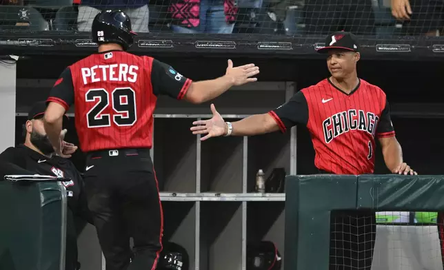 Chicago White Sox's Tristan Peters (29) celebrates with manager Will Venable, right, at the dugout after scoring on a Miguel Vargus sacrifice fly during the fifth inning of a baseball game against the Athletics in Chicago, Friday, July 10, 2026. (AP Photo/Paul Beaty)