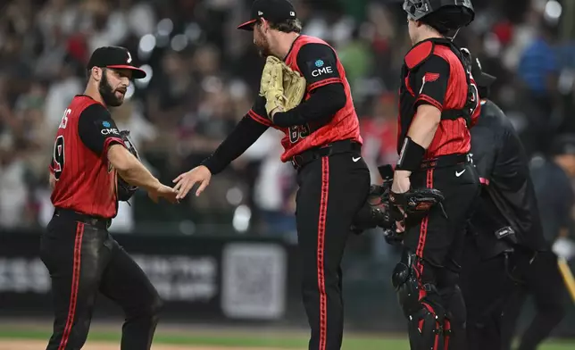 Chicago White Sox's Tristan Peters, left, celebrates with closing pitcher Tyler Davis, center, after defeating the Athletics in a baseball game in Chicago, Friday, July 10, 2026. (AP Photo/Paul Beaty)
