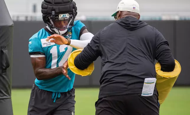 Jackonville Jaguars wide receiver and corner back Travis Hunter (12) runs drils during practice at the team's NFL football training camp, Wednesday, July 29, 2026, in Jacksonville, Fla. (AP Photo/Kelly Jordan)