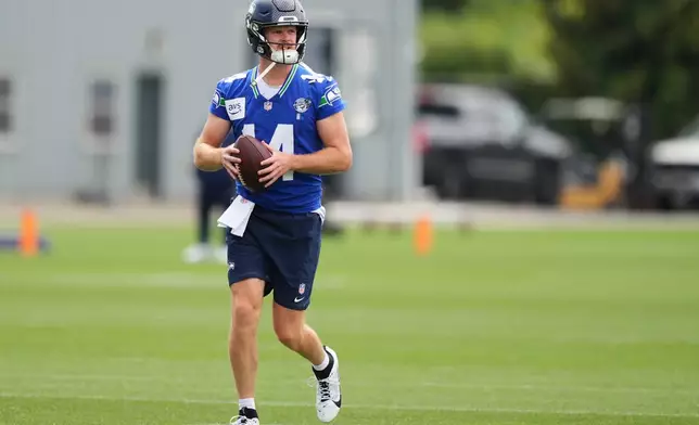Seattle Seahawks quarterback Sam Darnold carries a ball during the NFL football team's training camp, Sunday, July 26, 2026, in Renton, Wash. (AP Photo/Lindsey Wasson)