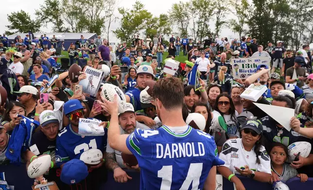 Seattle Seahawks quarterback Sam Darnold signs autographs during the NFL football team's training camp, Saturday, July 25, 2026, in Renton, Wash. (AP Photo/Lindsey Wasson)