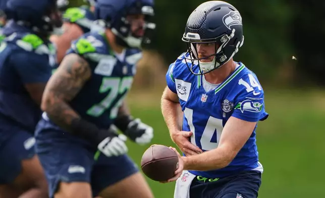 Seattle Seahawks quarterback Sam Darnold hands off the ball during the NFL football team's training camp, Saturday, July 25, 2026, in Renton, Wash. (AP Photo/Lindsey Wasson)