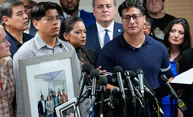Ronaldo Salgado, right, son of Lorenzo Salgado Araujo, speaks as his brother, Lorenzo Jr. holds family photographs during a news conference Wednesday, July 8, 2026, in Houston. (AP Photo/David J. Phillip)