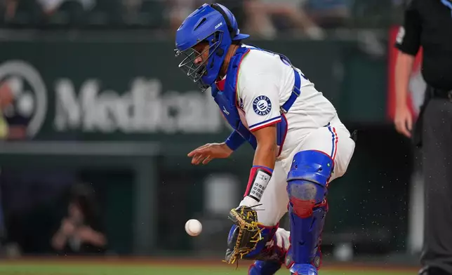 Texas Rangers catcher Elias DÌaz fields a throw from the outfield on a scoring double by Los Angeles Angels' Jorge Soler during the first inning of a baseball game, Tuesday, July 7, 2026, in Arlington, Texas. (AP Photo/Julio Cortez)