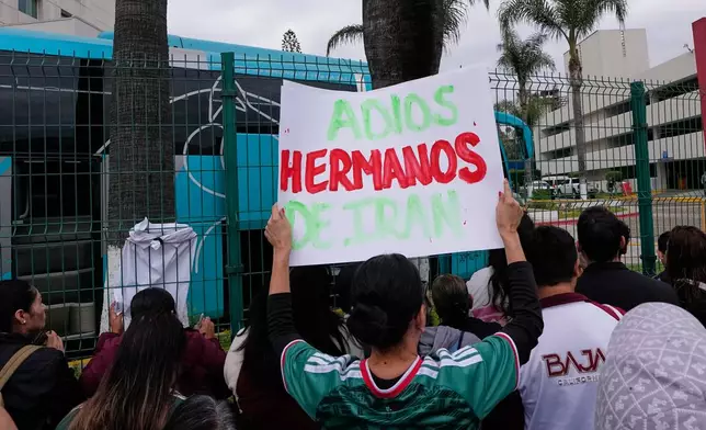 Fans greet members of the Iran World Cup soccer team as they leave their hotel for the airport Tuesday, June 30, 2026, in Tijuana, Mexico. (AP Photo/Gregory Bull)
