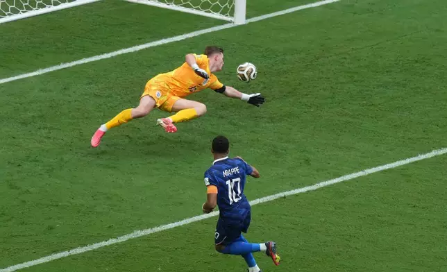 France's Kylian Mbappe (10) scores their first goal past England goalkeeper Dean Henderson (13) during the World Cup third-place playoff soccer match between France and England in Miami Gardens, Fla., Saturday, July 18, 2026. (AP Photo/Marta Lavandier)