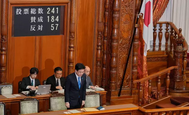 Japan's Chief Cabinet Secretary Minoru Kihara stands and bows after the Upper House passed a bill to revise the Imperial House Law during its plenary session in Tokyo, Friday, July 17, 2026. (AP Photo/Eugene Hoshiko)
