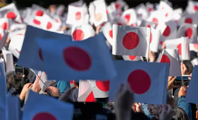 FILE - Well-wishers wave Japanese flags as Emperor Naruhito with his imperial families makes a public appearance at the balcony of Imperial Palace in Tokyo, Jan. 2, 2026. (AP Photo/Eugene Hoshiko, File)