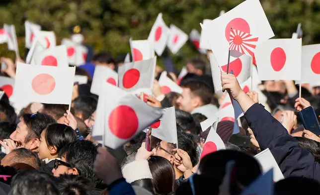 FILE -Well-wishers wave Japanese flags as Emperor Naruhito with his imperial families makes a public appearance at the balcony of Imperial Palace, Jan. 2, 2026, in Tokyo. (AP Photo/Eugene Hoshiko, File)