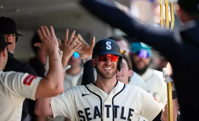 Seattle Mariners' Mitch Garver holds the trident in the dugout while celebrating his two-run home run against the Toronto Blue Jays during the fourth inning of a baseball game, Sunday, July 5, 2026, in Seattle. (AP Photo/Lindsey Wasson)