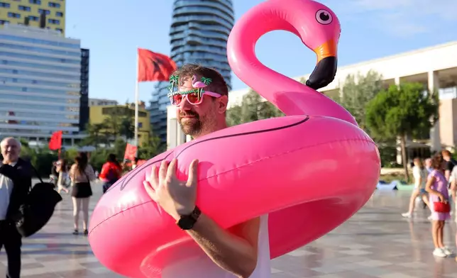 A protester holds an inflatable flamingo during a protest against plans for a luxury construction project linked to U.S. President Donald Trump's son-in-law, Jared Kushner, in Tirana, Albania, Saturday, July 4, 2026.(AP Photo/Hameraldi Agolli)