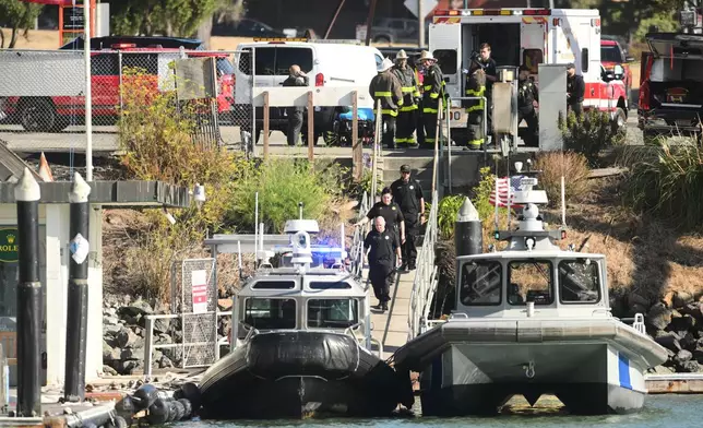 Emergency crews gather at a dock near the site of a pontoon boat fire on Tuesday, July 14, 2026, in San Francisco. (AP Photo/Noah Berger)