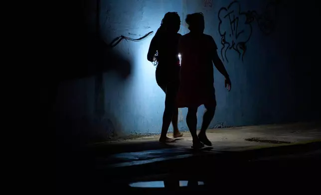 People walk in the night during a blackout in Havana, Cuba, Friday, July 10, 2026. (AP Photo/Ramon Espinosa)