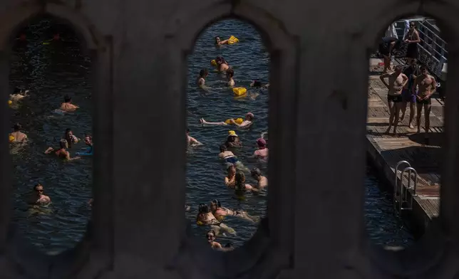People swim in the Seine River in Paris during a heat wave, Saturday, July 11, 2026. (AP Photo/Aurelien Morissard)