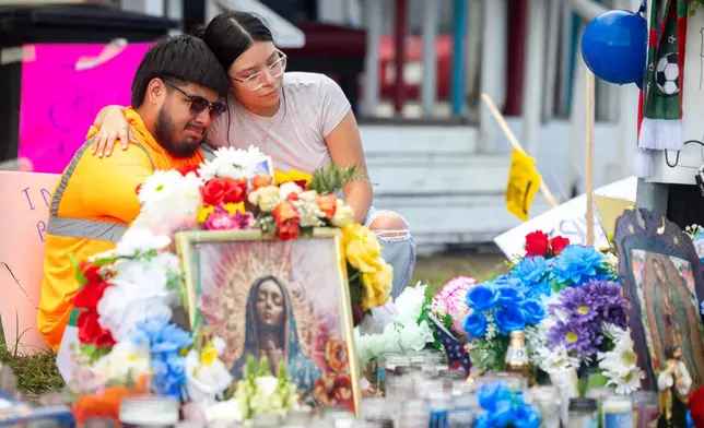 Albert Salgado, left, is comforted by his girlfriend at the site where his uncle Lorenzo Salgado Araujo was shot by an ICE officer in Houston on Friday, July 10, 2026. (AP Photo/Annie Mulligan)