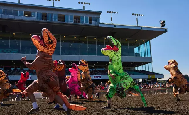 Participants sprint to the finish line during the teen race during the T-Rex World Championship Races at Emerald Downs, Sunday, July 12, 2026, in Auburn, Wash. (AP Photo/Lindsey Wasson)